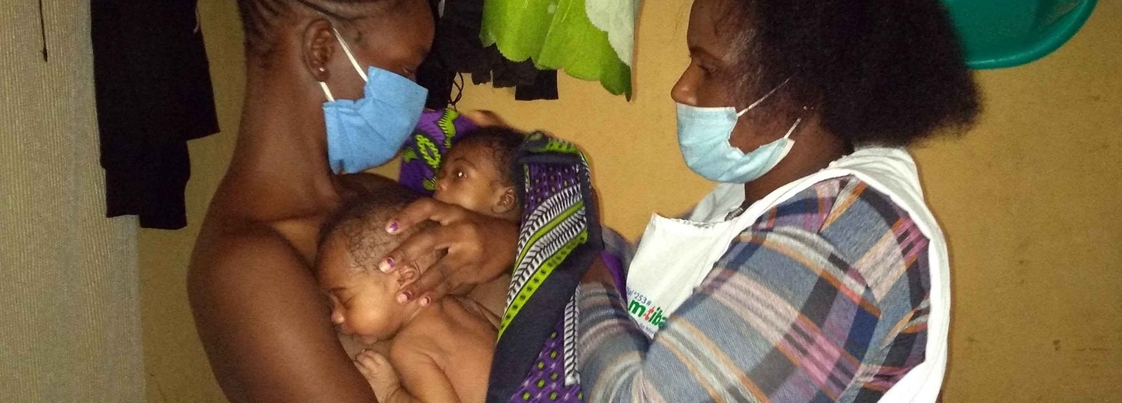 Lavender Atieno receives guidance from Afya Jijini Kangaroo Mother Care Champion Mary Wairimu, affiliated with Mama Lucy Kibaki Hospital, to practice the KMC technique at her home in Kayole in Nairobi County. 