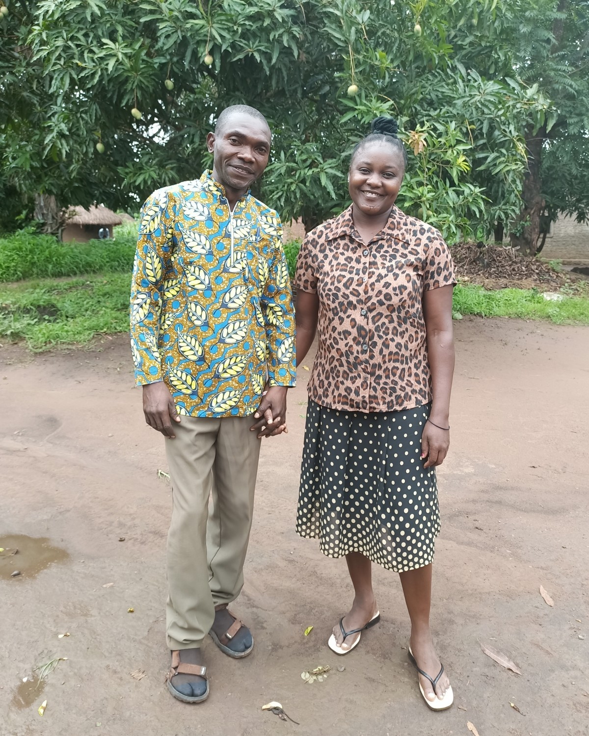 A husband and wife hold hands and smile