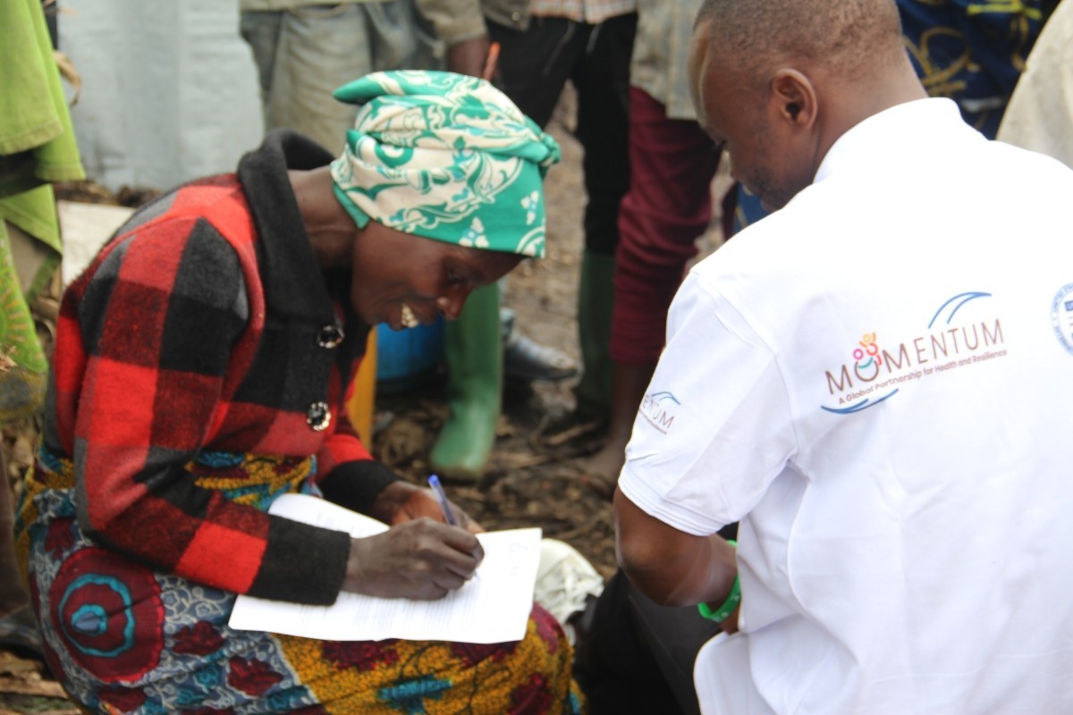 Mussa Stanis interviews a community member in the DRC as part of his job with MOMENTUM Integrated Health Resilience.
