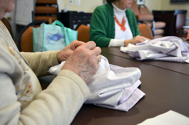 Glenda Johnson rips a hem from a flannel sheet in preparation for making baby blankets for Safe Motherhood Kits™