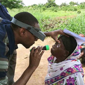 Tandahimba District eye coordinator Pirmin Eriyo examines a patient in Nanhyanga, Tanzania for trachoma - a neglected tropical disease. (IMA World Health/Matt Hackworth)