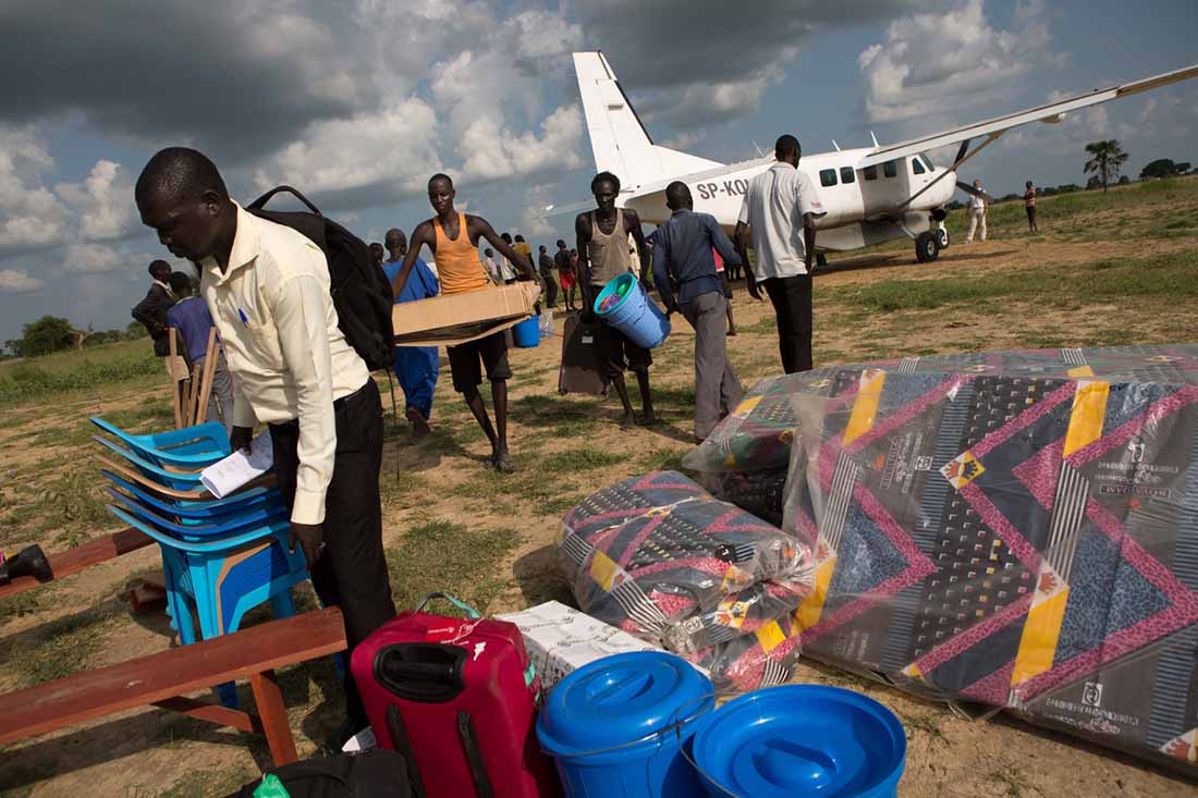 A team unloads LWR-provided medical center supplies at the dirt airstrip in Duk Padiet, in South Sudan's Jonglei state, September 27, 2017. Small charter flights are often the only way to get supplies to remote villages in the rainy season, when the dirt roads that connect them become impassibly muddy. Lutheran World Relief has partnered with IMA World Health and in turn, the John Dau Foundation, to set up and run three life-saving medical stabilization centers, including in Duk Padiet, to treat young children and lactating mothers at risk of death from starvation. The project, called “Providing Emergency Nutrition Services in South Sudan” will reach just under 100,000 individuals. (photo by Allison Shelley for Lutheran World Relief)